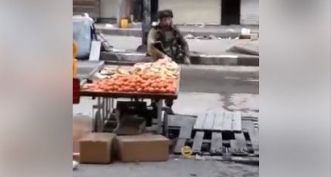 VRAIMENT PITOYABLE : Un soldat de l&rsquo;occupation israélienne vole des fruits à un palestinien lors des affrontements à Al Khalil.