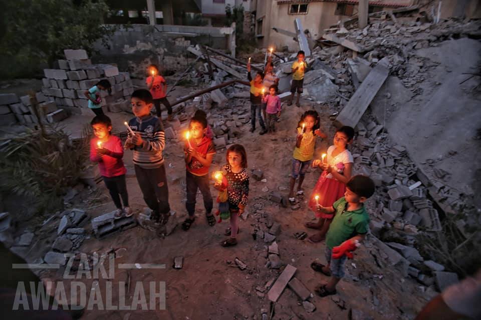 Les enfants palestiniens allument des bougies sur des décombres de maisons, démolis dans la dernière agression israélienne sur Gaza, en mémoire aux 27 vies assassinées par les machines