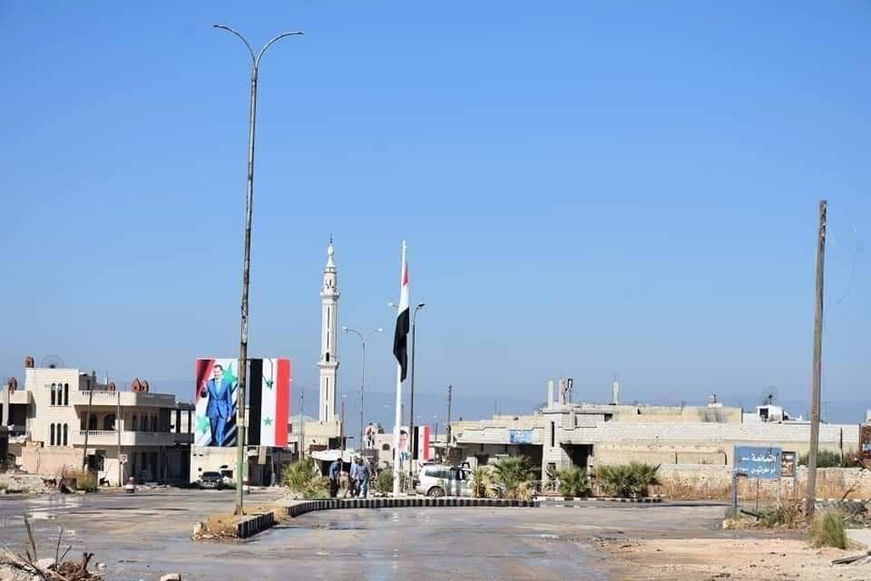 Les soldats de l'Armée Arabe Syrienne élèvent le drapeau Syrien et le portrait du défunt Président Hafez Al Assad à Khan sheikhoun.1