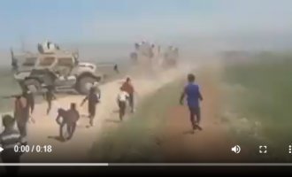 Des enfants syriens chassent une patrouille des occupants américains en Syrie, près de la ville d’Al Qamishli, aujourd’hui.